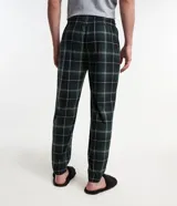 Pantalón de pijama masculino de fleece con estampado de cuadros en tonos verde, negro y blanco. Cuenta con cintura elástica, cordón de ajuste, bolsillos laterales y puños elásticos.