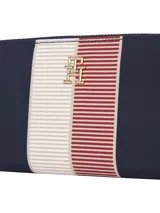 Billetera Tommy Hilfiger con cierre de cremallera, diseño a rayas horizontales en azul marino, blanco y rojo. Incluye tres compartimentos principales, bolsillo interior con cremallera para monedas, dos compartimentos interiores para billetes y múltiples ranuras interiores para tarjetas.