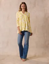 Blusa amarilla con estampado floral blanco, escote en V y mangas 3/4.