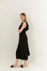 Vestido midi negro con cuello en V y volados en el escote y el ruedo.