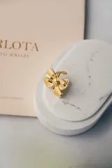 Anillo abierto dorado con forma de flor.