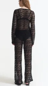 Pantalón calado negro de encaje con diseño floral, corte palazzo y cintura alta.