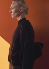 Sweater negro de punto grueso con cuello redondo y puños elásticos.