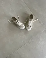 Zapatillas de lona celeste con cordones blancos y suela blanca.