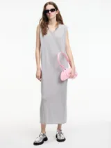 Vestido largo de tejido de punto color gris, con textura metalizada, cuello escote en V y tajos laterales. Sin mangas.
