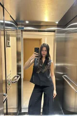 Pantalón negro de corte palazzo y tiro alto, con chaleco haciendo juego.