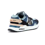 Zapatilla deportiva Austral modelo Ushuaia, de estilo chunky/retro, con combinación de colores azul oscuro, celeste claro, negro y detalles en beige/nude. Presenta una capellada de malla y gamuza sintética, con una entresuela blanca con salpicaduras negras y el logo de Austral 1997 en el lateral.