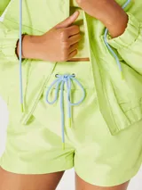 Short celeste con cintura elastizada y cordón de ajuste verde flúor.