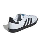 Championes Adidas Samba Og de cuero blanco con detalles en negro y suela de goma color caramelo.