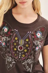 Remera marrón de jersey flamé con calce suelto y bordado frontal centrado con diseño de mariposa y flores.