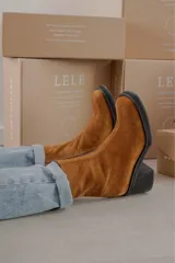 Bota de cuero color marrón con caña media y punta cuadrada.