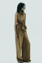 Pantalón palazzo color verde oliva de tejido fluido, tiro medio, cintura elástica ajustable con cordones y bolsillos laterales.