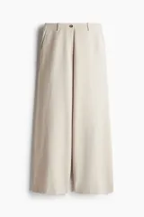 Pantalón de corte holgado color beige, confeccionado en mezcla de lino. Modelo de tiro alto con cierre y botón, bolsillos al bies, bolsillos insertados atrás y piernas amplias.