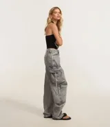 Pantalón baggy gris de jeans con bolsillos cargo laterales y tiritas ajustables.