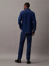 Jeans de denim azul índigo oscuro, corte slim fit, talle medio y pierna estrecha.