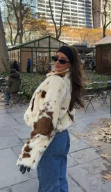 Campera corta de piel sintética con estampado vacuno en tonos crema y marrón chocolate, corte recto y forro interior.