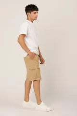 Bermuda color beige de gabardina con licra y corte a la rodilla. Cuenta con bolsillos laterales tipo cargo con solapa y bolsillos delanteros y traseros.