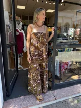 Vestido largo estampado en tonos marrones y beige, con escote cuadrado y tirantes anchos en ecocuero beige.