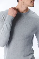 Buzo de punto gris melange con cuello redondo.