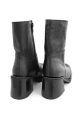 Bota de cuero negro con cierre lateral, altura de caña de 15 cm y taco de 7 cm.