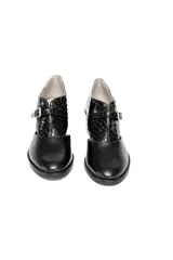 Zapato de cuero negro con detalle de piel reptil en la parte trasera, corte lateral y hebilla dorada. Tacón cuadrado de altura media.