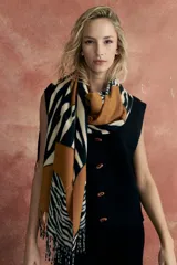 Bufanda larga con estampado de cebra en tonos beige, marrón y negro, con flecos en los extremos.