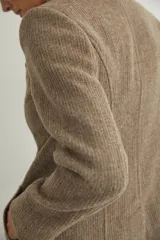 Tapado corto entallado color marrón claro con textura de espiga, cuello solapa y manga larga. Cierre frontal con botones.