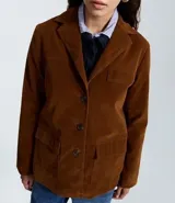 Blazer color marrón de gamuza sintética, con cuello de solapa, cierre frontal con botones y bolsillos delanteros.