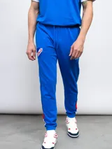 Pantalón de felpa azul con cortes, cambios de color y piping.