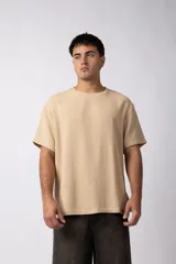 Remera color beige de lino con textura entramada, cuello redondo y mangas cortas.