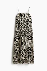 Vestido midi con breteles spaghetti y estampado abstracto en blanco y negro.
