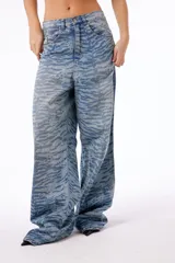 Pantalón de jean oversized de tiro bajo, color azul lavado, con estampado de tigresa grabado con láser.