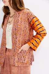 Kimono de viscosa con bordado matelasé vertical y mix de estampas en tonos naranja, rosa y marrón.