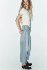 Pantalón de jean celeste de corte amplio, con tiro medio, cinco bolsillos y costuras torcidas.