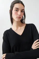 Sweater verde de tejido de punto, con escote en V y mangas largas.