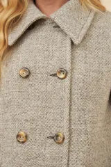 Chaquetón de lana fina color beige con cuello solapa, doble abotonadura frontal, bolsillos ojal y forro al tono.