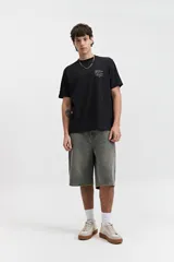 Remera de manga corta color verde claro con estampado de texto en el pecho, de corte oversize y cuello redondo.