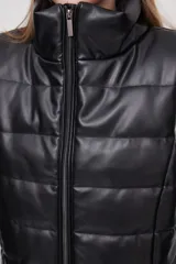 Chaleco negro sin mangas de material sintético, con diseño acolchado y corte recto.
