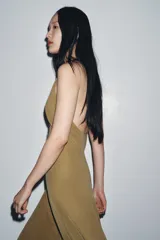 Vestido largo marrón de Zara Woman Collection, confeccionado en viscosa y lyocell. Presenta escote en pico y tirantes finos cruzados en la espalda.