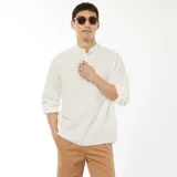 Camisa blanca de manga larga con cuello mao y textura gofrada.