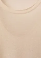 Jersey de punto fino color beige, con cuello redondo y mangas 3/4. Diseño oversize.