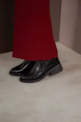 Bota corta color marrón con textura símil cuero de cocodrilo, caña baja, punta redondeada y taco cuadrado.