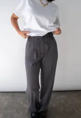 Pantalón sastrero gris a rayas verticales, de tiro alto con bolsillos y pretina trasera elastizada.