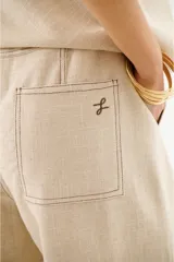 Pantalón de lino azul marino de corte recto con cintura alta y cordón ajustable. Presenta costuras en contraste color blanco.