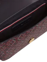 Cartera cruzada con solapa frontal, confeccionada en poliuretano con forro de poliéster. Presenta un estampado integral con el monograma TH en tonos azul marino y bordó, con detalles en blanco. Cuenta con correa larga ajustable y el monograma TH metálico dorado en la solapa.