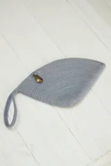 Sobre de mano color beige, confeccionado en soga de algodón trenzada, con forma irregular y cierre con broche de bronce.