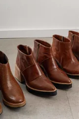 Botines de cuero color marrón con cierre lateral, punta fina y taco de madera.