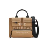Bolso tote mediano Marc Jacobs modelo The Cargo Canvas, color beige con detalles en negro. Confeccionado en lona resistente, con múltiples bolsillos externos, doble asa de mano y correa bandolera ajustable y extraíble. Incluye logo bordado en el frente.