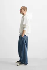 Pantalón de jean negro, corte relaxed fit, con bolsillos frontales y traseros tipo parche, tira multifunción y bolsillo tipo parche en las piernas. Tiene efecto lavado y cierre frontal con cremallera y botón.