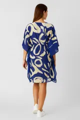 Túnica holgada de algodón con estampado abstracto en tonos negro y beige, cuello en V y cordón ajustable a la cintura.